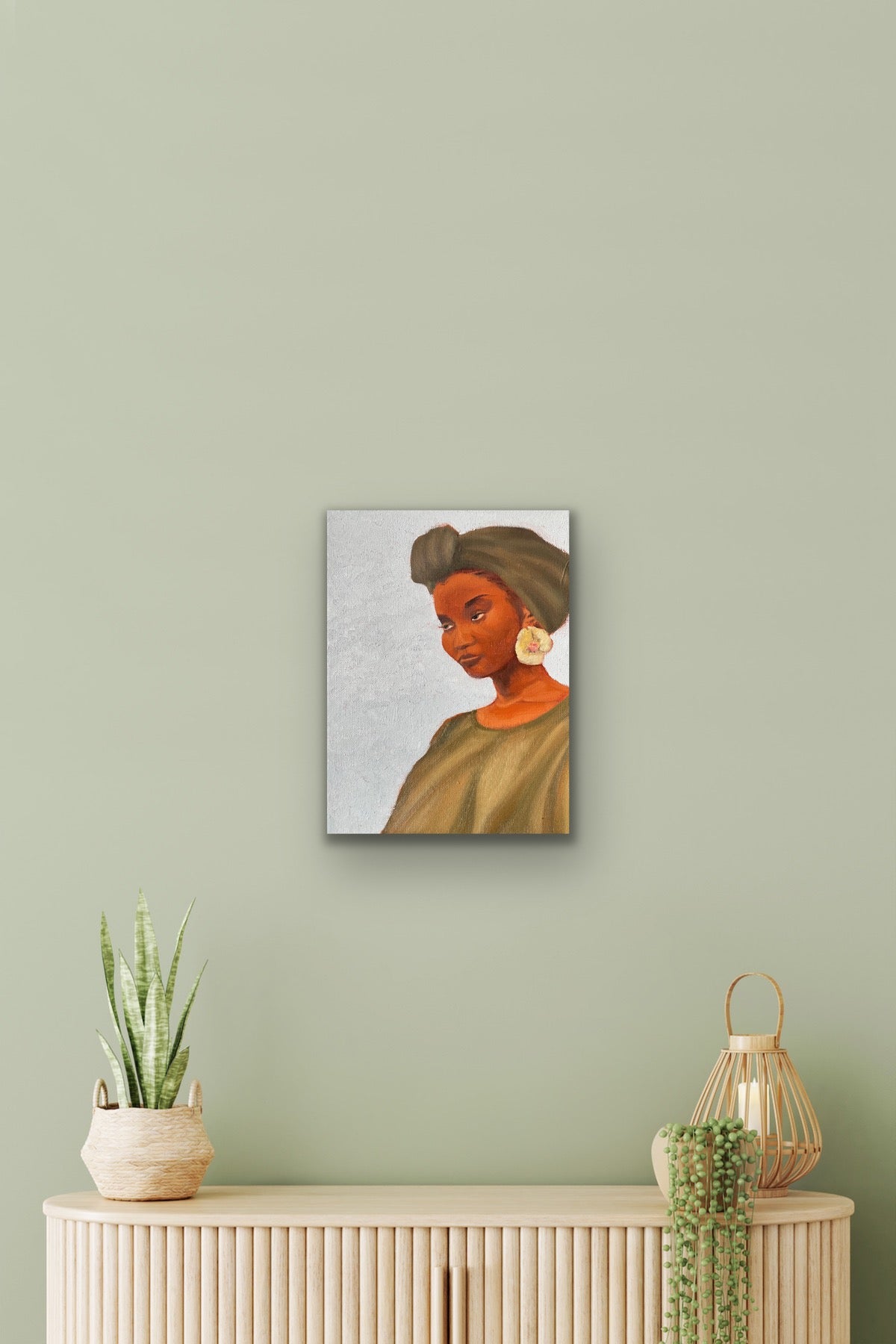 Rock oil painting of woman with green headwrap, dress and flower earring